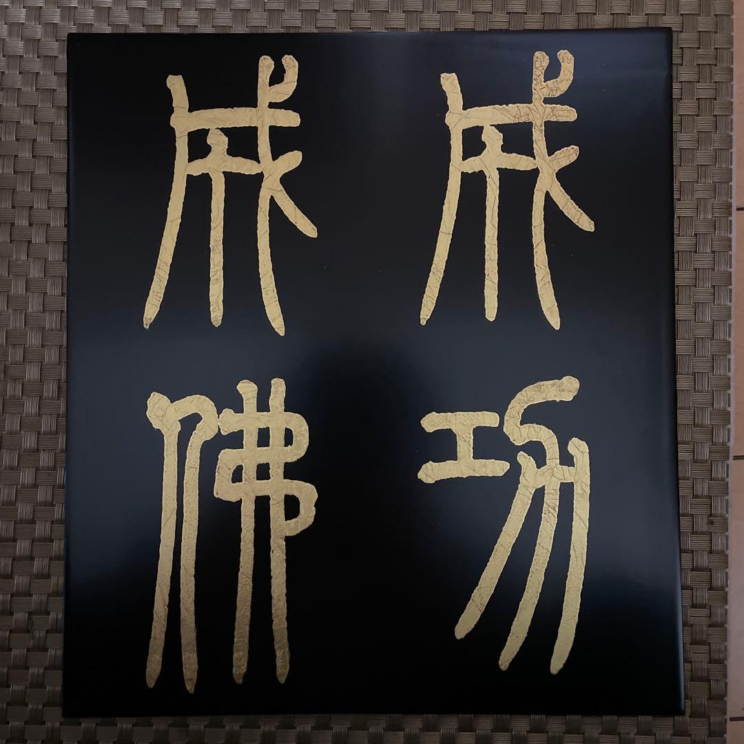 「篆書体　成功成仏」紫山作。漆塗り木板の上に金字で成功・成仏とかかれています。